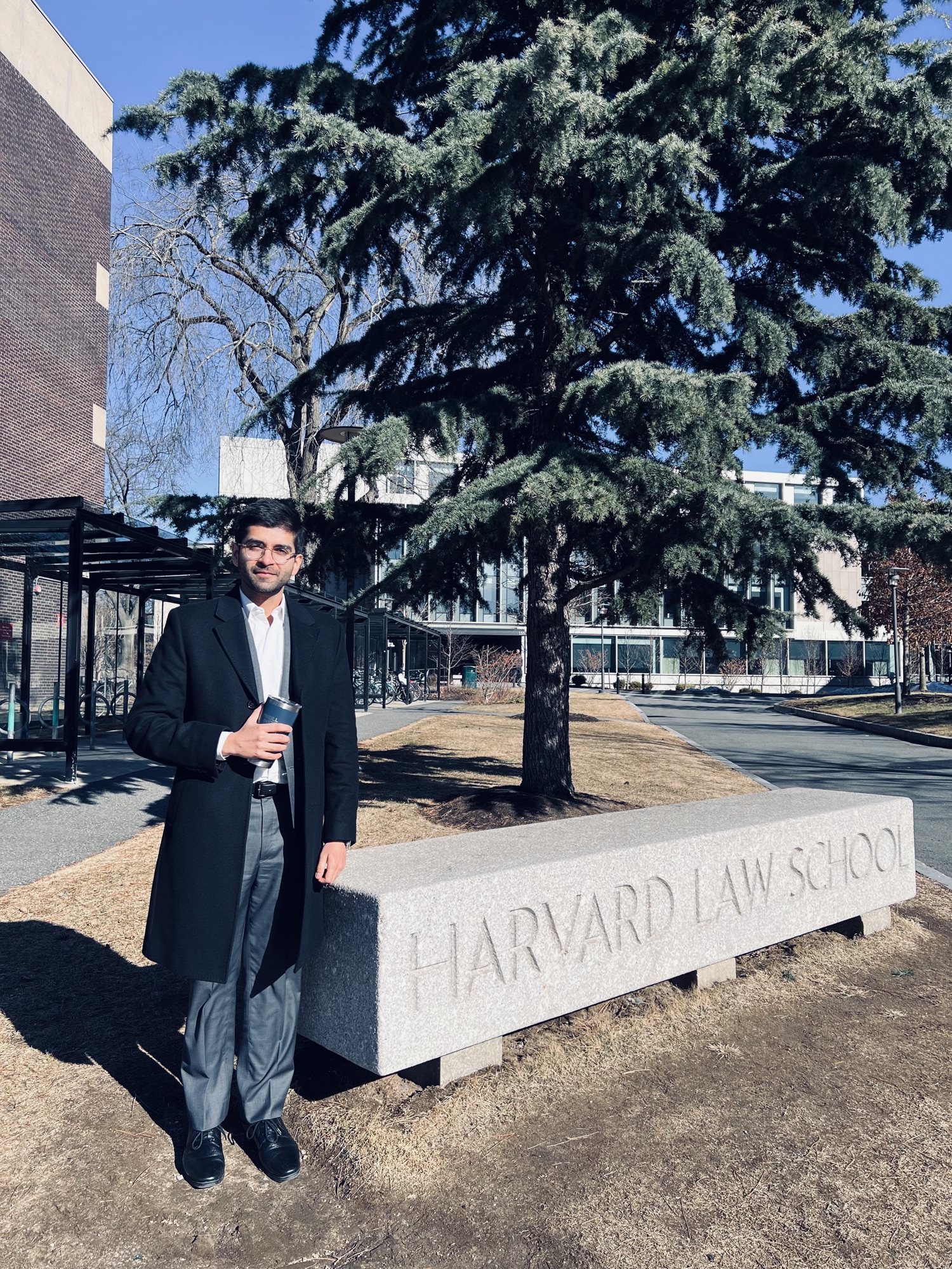 Kashish Aneja beside the Harvard Law School sign