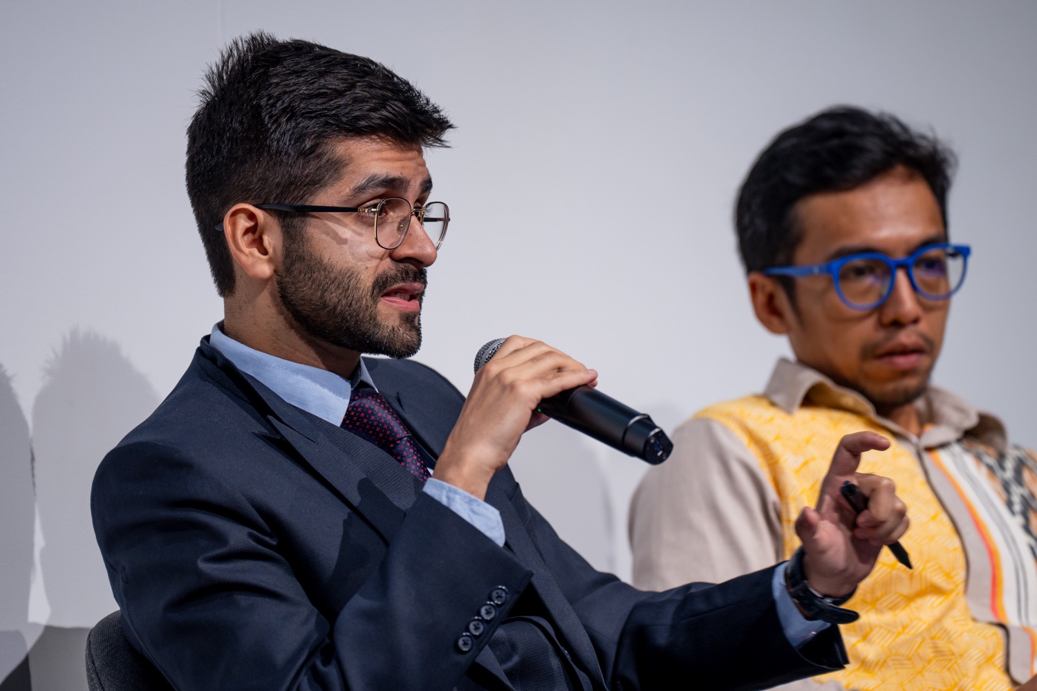 Kashish Aneja speaking on a panel beside a colleague